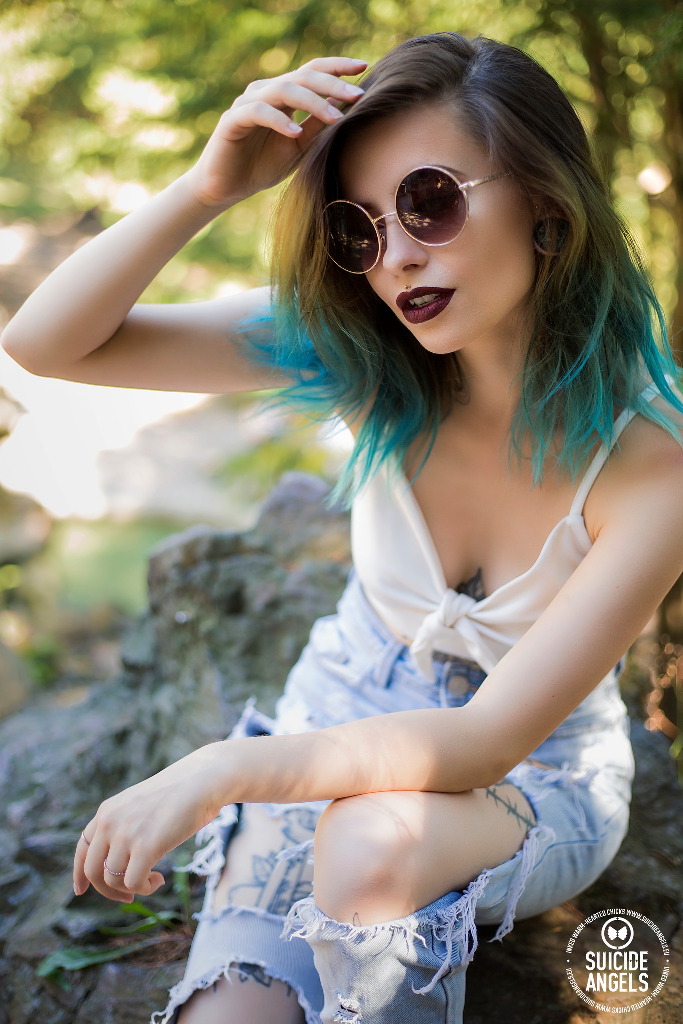 modre vlasy zena potetovana bryle lennonky